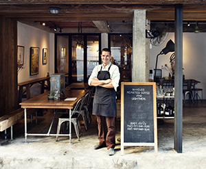 Owner of an Ocean County open air cafe standing next to chalkboard sign