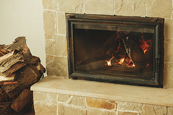 Light stone hearth fireplace burning a clean fire after Tinton Falls fireplace service