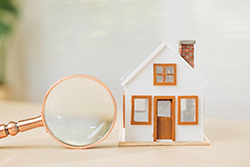 Magnifying glass next to a toy home